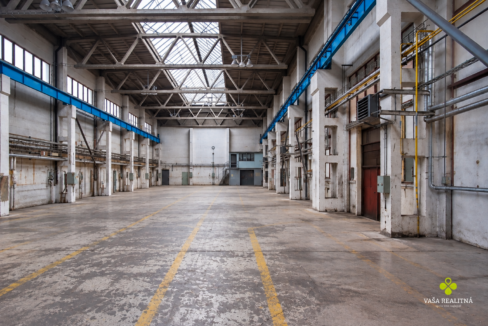 Vyprázdnená industriálna hala s logom